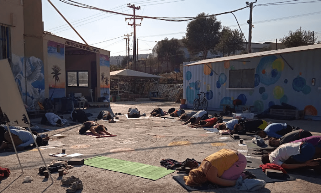 People from local, volunteer and refugee communities come together for a Yoga and Sports yoga workshop in the One Happy Family grounds in Lesvos. Photo by Debi Altman.